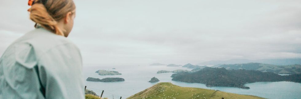 A Woman Standing on the Hill on the Shore in the Waikato Region in New Zealand